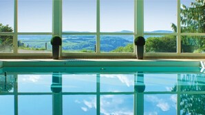 Piscina con vista a un paisaje a través de amplias ventanas.