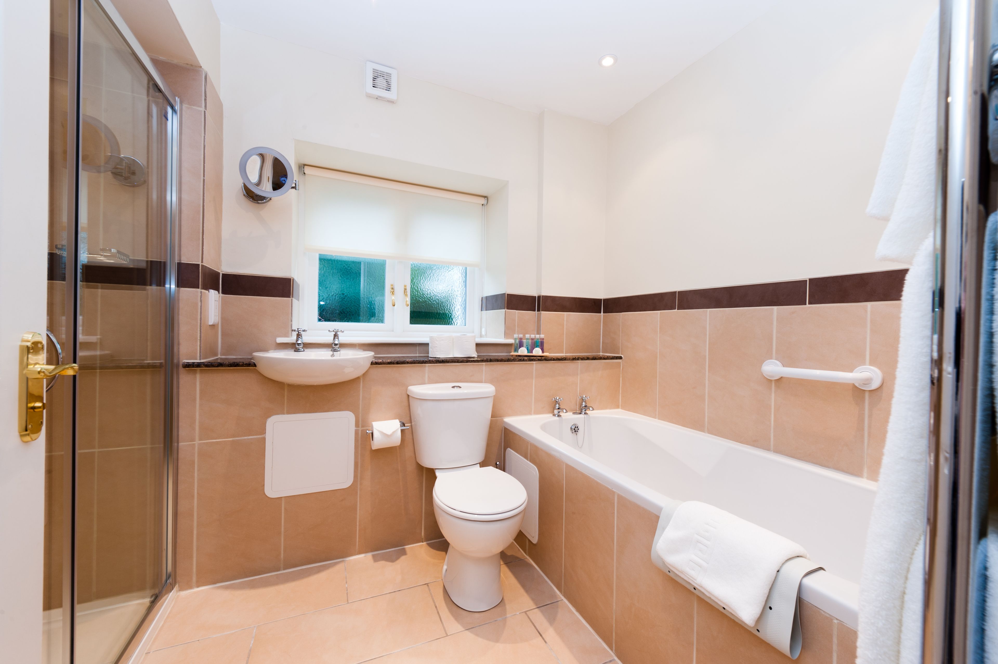A bathroom with a glass shower enclosure, a toilet, a sink, and a bathtub.