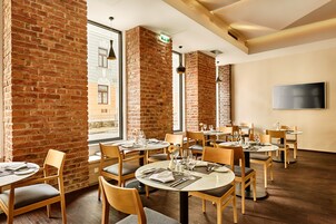 Um restaurante com paredes de tijolo, mesas e cadeiras de madeira.