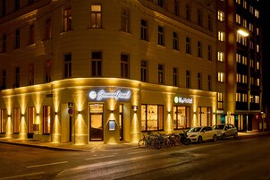 A hotel with a sign reading "Gaumenfreund" and "Hotel". There are bicycles parked outside and cars parked on the street.