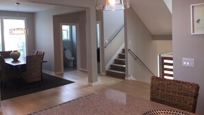 Een modern interieur met een eethoek, trap en hanglamp.