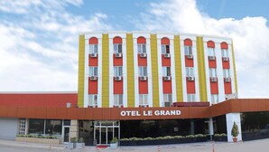 Un hotel de varios pisos con un letrero llamativo que dice "OTEL LE GRAND".