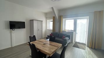 Comfort Apartment | Coin séjour | TV connectée de 40 pouces avec chaînes par satellite, télévision