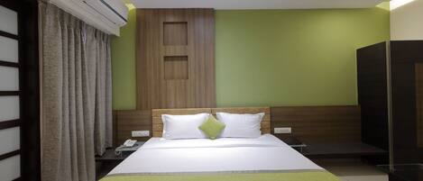 A hotel room with a bed, a nightstand, a phone, and a wardrobe.