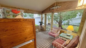 A wooden deck with a bed, a chair, a table, and a lamp. -  Ocean Lakes. Pet friendly One Story  with ramp. Complimentary golf cart. (Myrtle Beach)