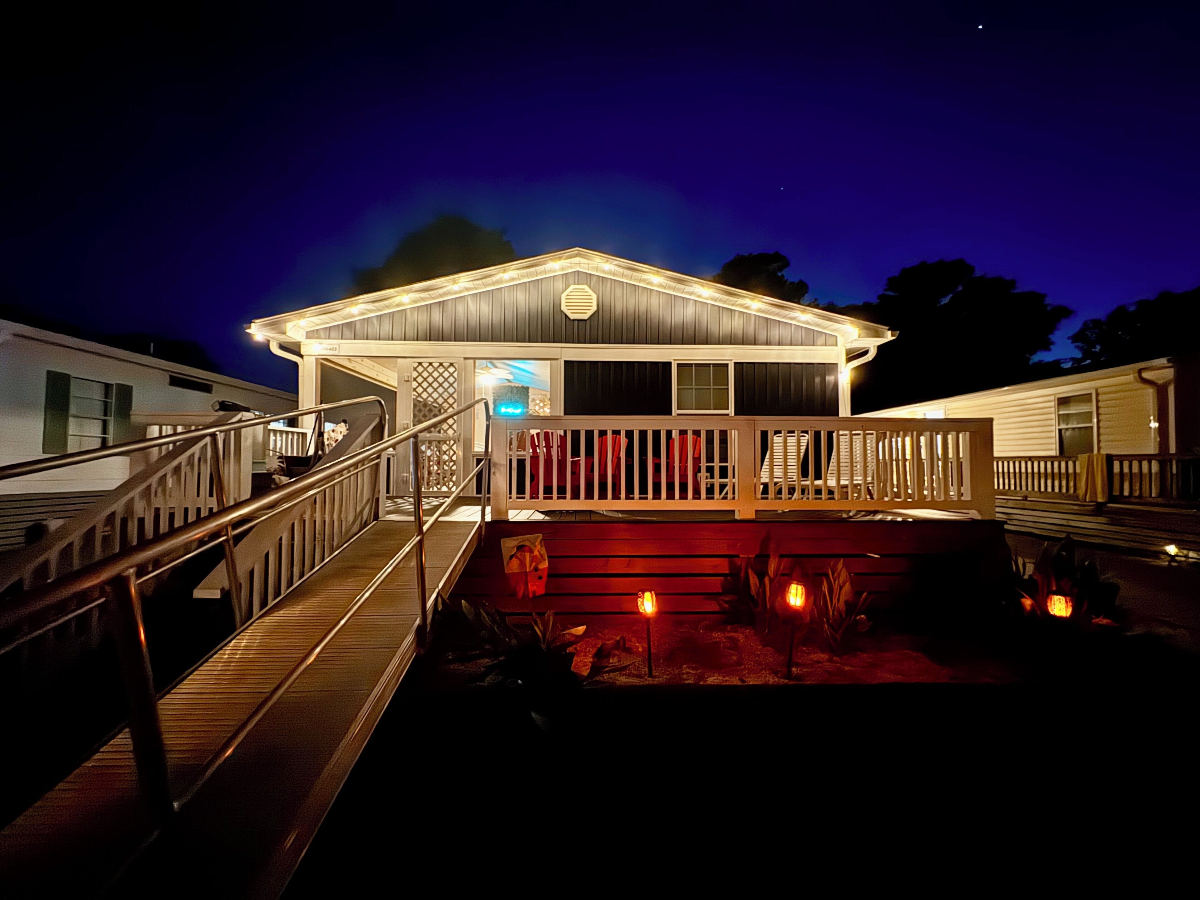 A two-story building with a covered deck and a staircase leading to the entrance.