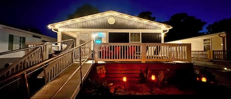 A two-story building with a covered deck and a staircase leading to the entrance.
