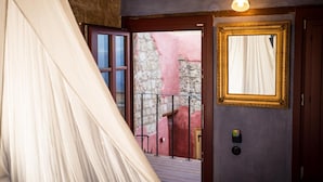 A room with a bed, a window with curtains, a door, and a wall-mounted light fixture. - Rodi Hotel - Adults Only (Rhodes)