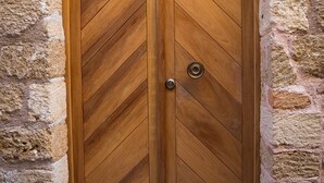 A wooden double door with a chevron pattern, set in a stone archway. - Rodi Hotel - Adults Only (Rhodes)