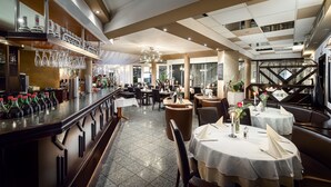 A restaurant with a bar area, multiple dining tables, and a modern interior design. - Sunibel Inn Hotel (Reinheim)