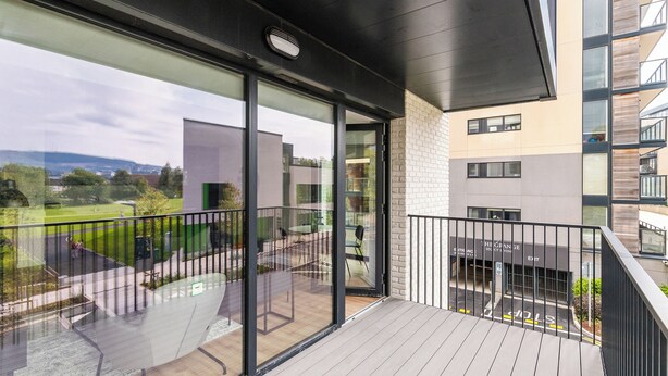 A balcony with a view of a green park and a building with a sign that reads "The Orange See City." - The Grange Dublin (Dublin)