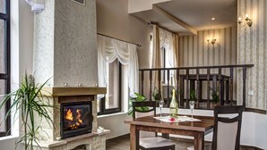 Una sala de estar acogedora con chimenea, una mesa de comedor y asientos cómodos.