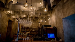 Un bar con lámparas colgantes y una pantalla de televisión.