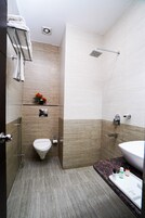 A modern bathroom with a toilet, shower, and sink.