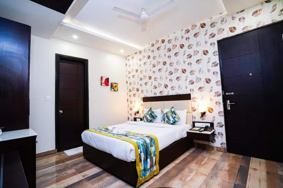 A bedroom with a bed, bedside tables, a wardrobe, and a ceiling fan.