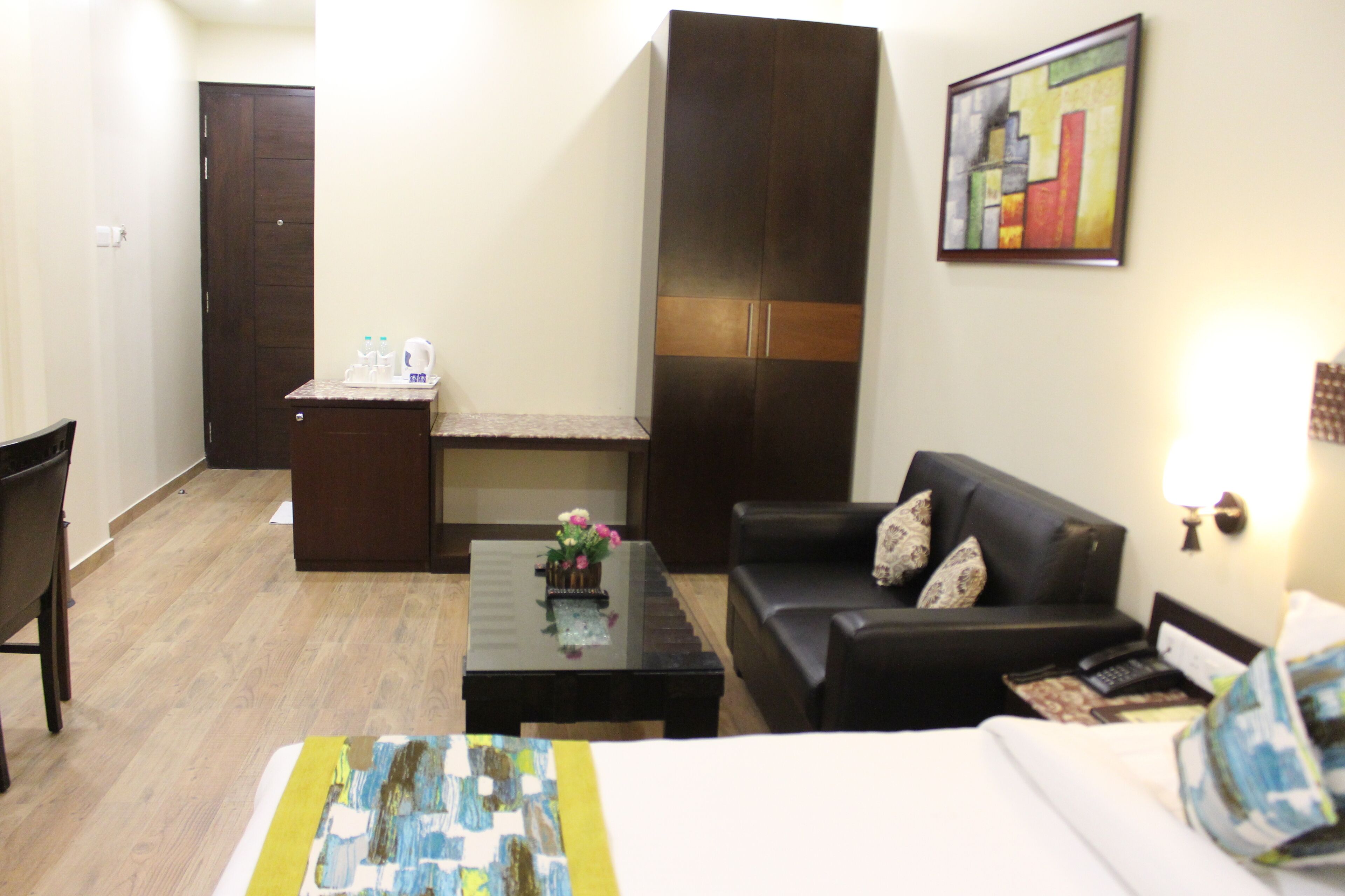Una habitación de hotel con cama, sofá, mesa de centro, escritorio y armario.