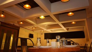 Un comedor con una mesa redonda, sillas e iluminación colgante.