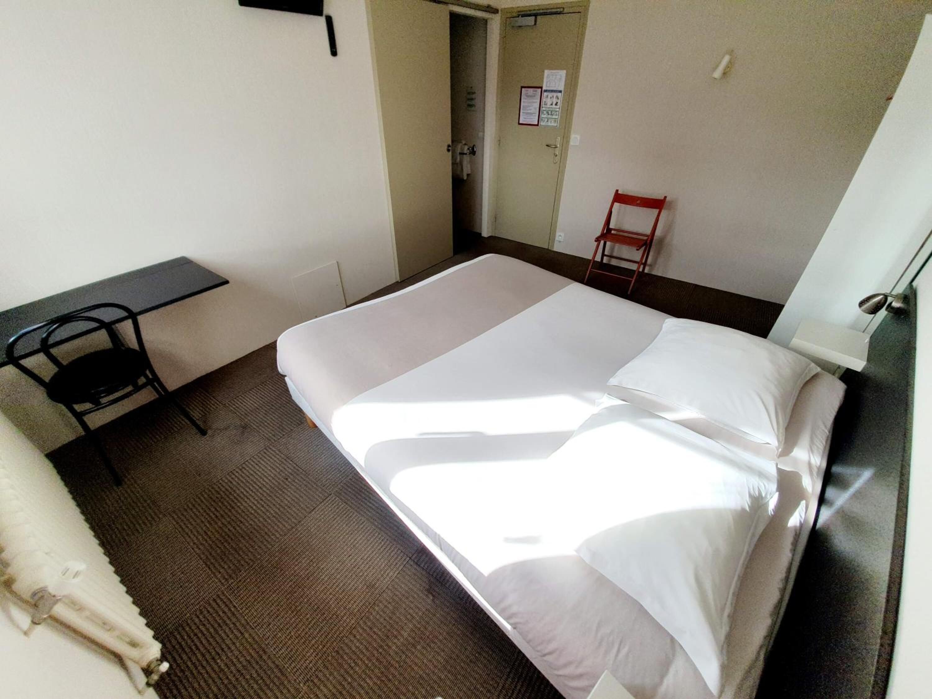 Ein Hotelzimmer mit einem Bett, einem Schreibtisch und einem Sessel.