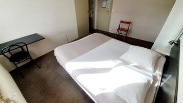 Ein Hotelzimmer mit einem Bett, einem Schreibtisch und einem Sessel.