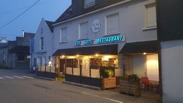 Een gebouw met een bar, hotel en restaurant, met een bord waarop