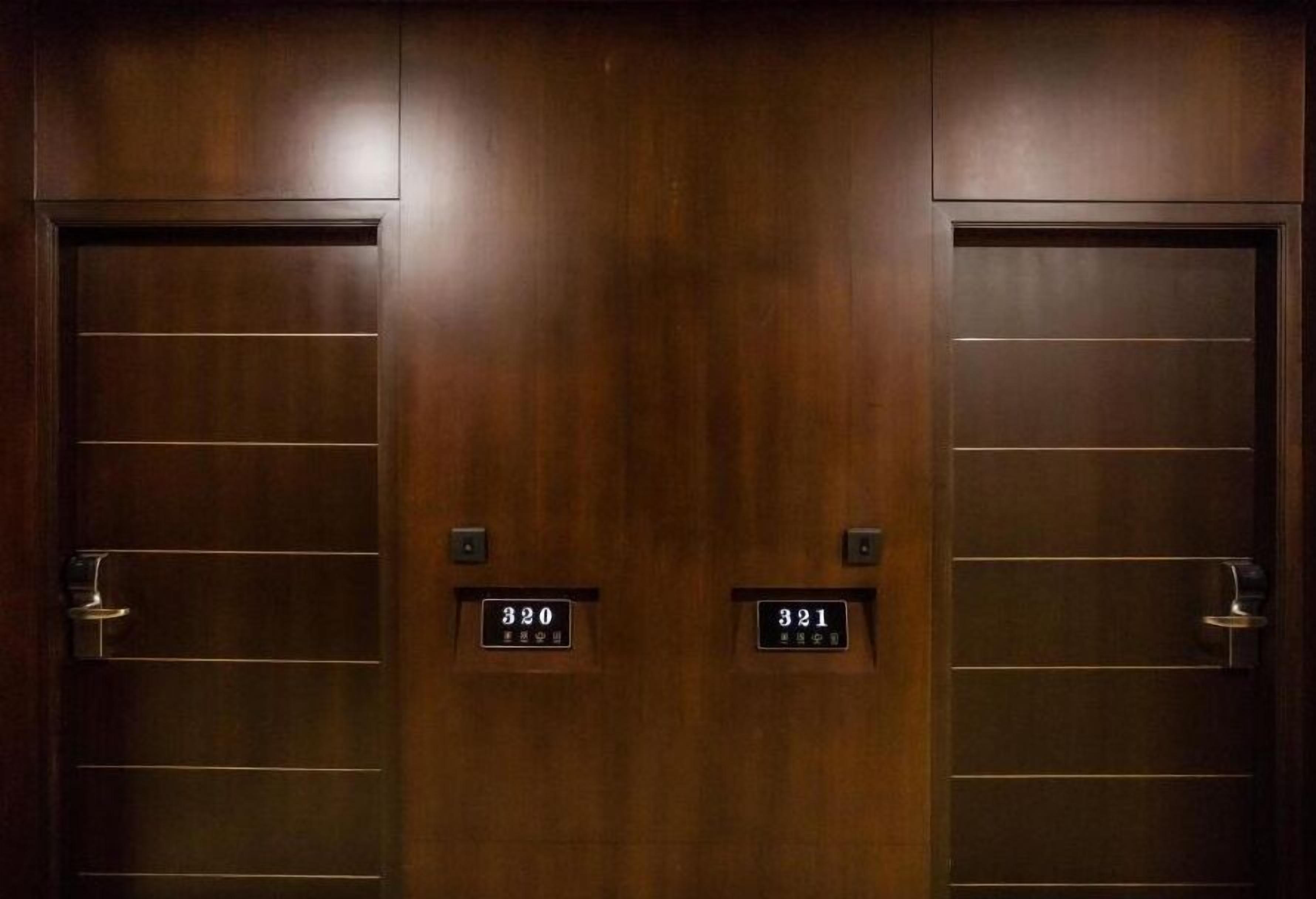 Un juego de puertas dobles con los números de habitación 320 y 321, indicando un hotel u otro alojamiento similar.