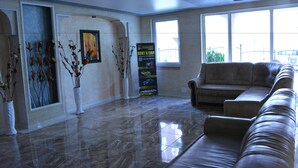 A spacious lobby with a leather sofa, a large window, and a 'Rent a Car' sign. - VIP Zone Apartments (Sunny Beach)
