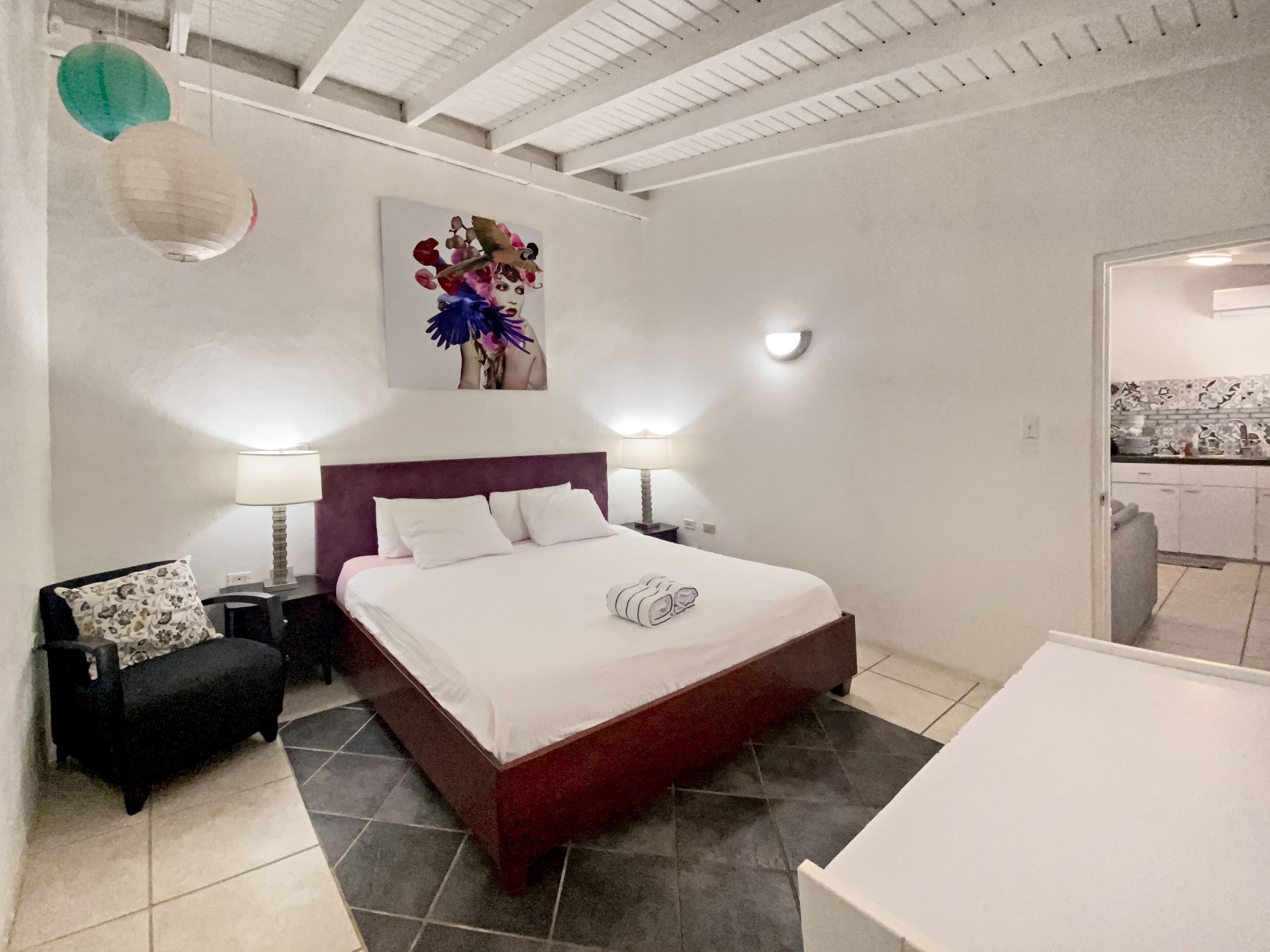 Une chambre à coucher avec un grand lit, deux tables de chevet, une chaise et une petite table.