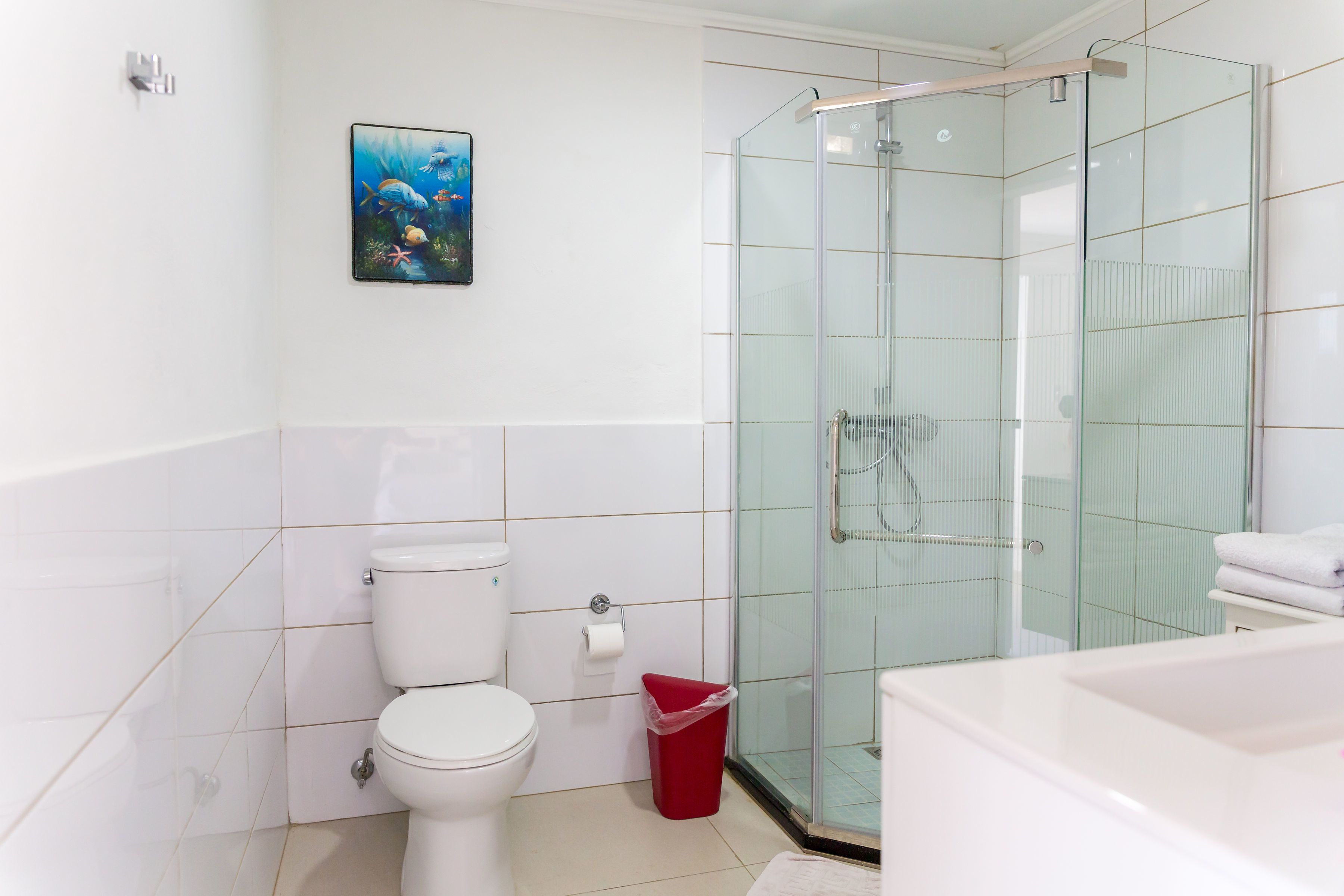 Une salle de bain moderne avec une douche à parois de verre, des toilettes et une baignoire.