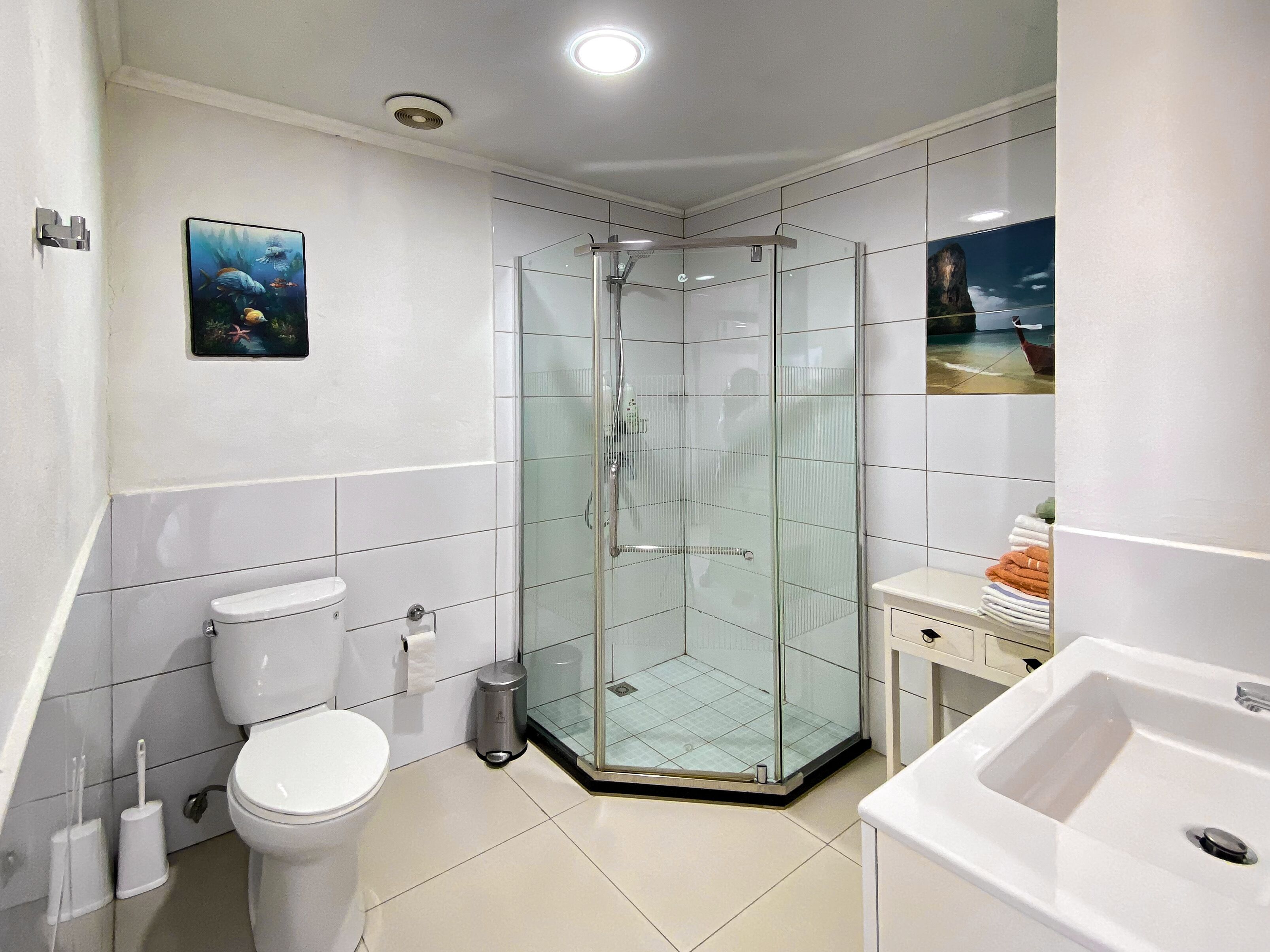 Une salle de bain moderne avec une douche à parois de verre, des toilettes et un lavabo.