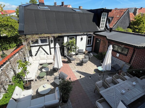 A rooftop patio with outdoor seating, a small table, and a potted plant. - Hotell Bäckagården (Ystad)