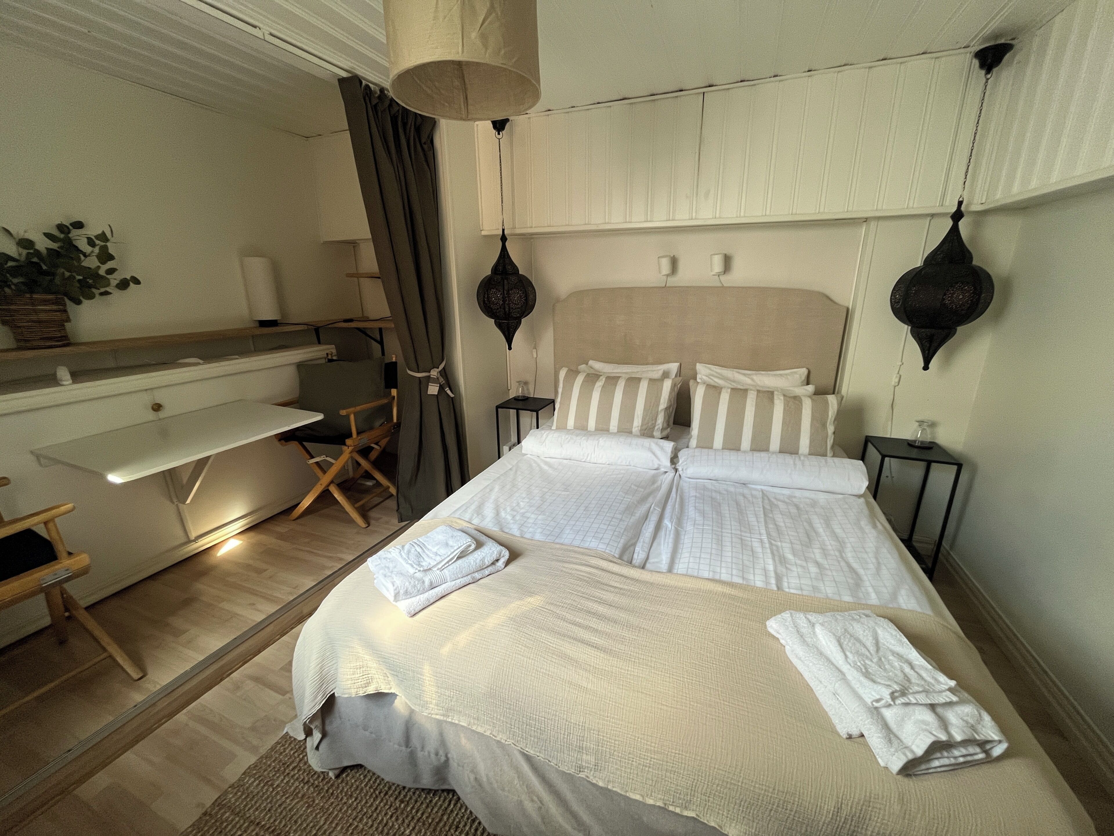 A hotel room with a bed, a desk, and a chair.