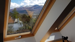 A skylight with a view of a mountain and a village. - Treetops B&B (Fort William)