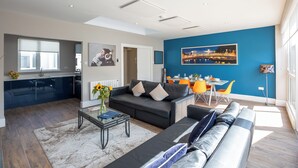 A modern living room with a sofa, a coffee table, and a dining area with a table and chairs. - Temple Bar Crowne Square Apartments (Dublin)