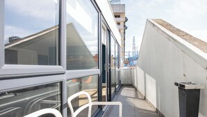 A narrow corridor with glass doors and windows, leading to a building with a tiled roof and a visible construction crane in the background. - Temple Bar Crowne Square Apartments (Dublin)