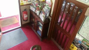 Een kleine, afgesloten ruimte met een brandblusser, een bord met de tekst 'Sunny Side' en een bord met de tekst 'Eetzaal'.