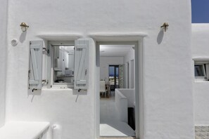 A white building with a door leading to a room with a view.