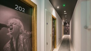 Un pasillo con puertas numeradas 202 y 203, suelo alfombrado e iluminación empotrada.
