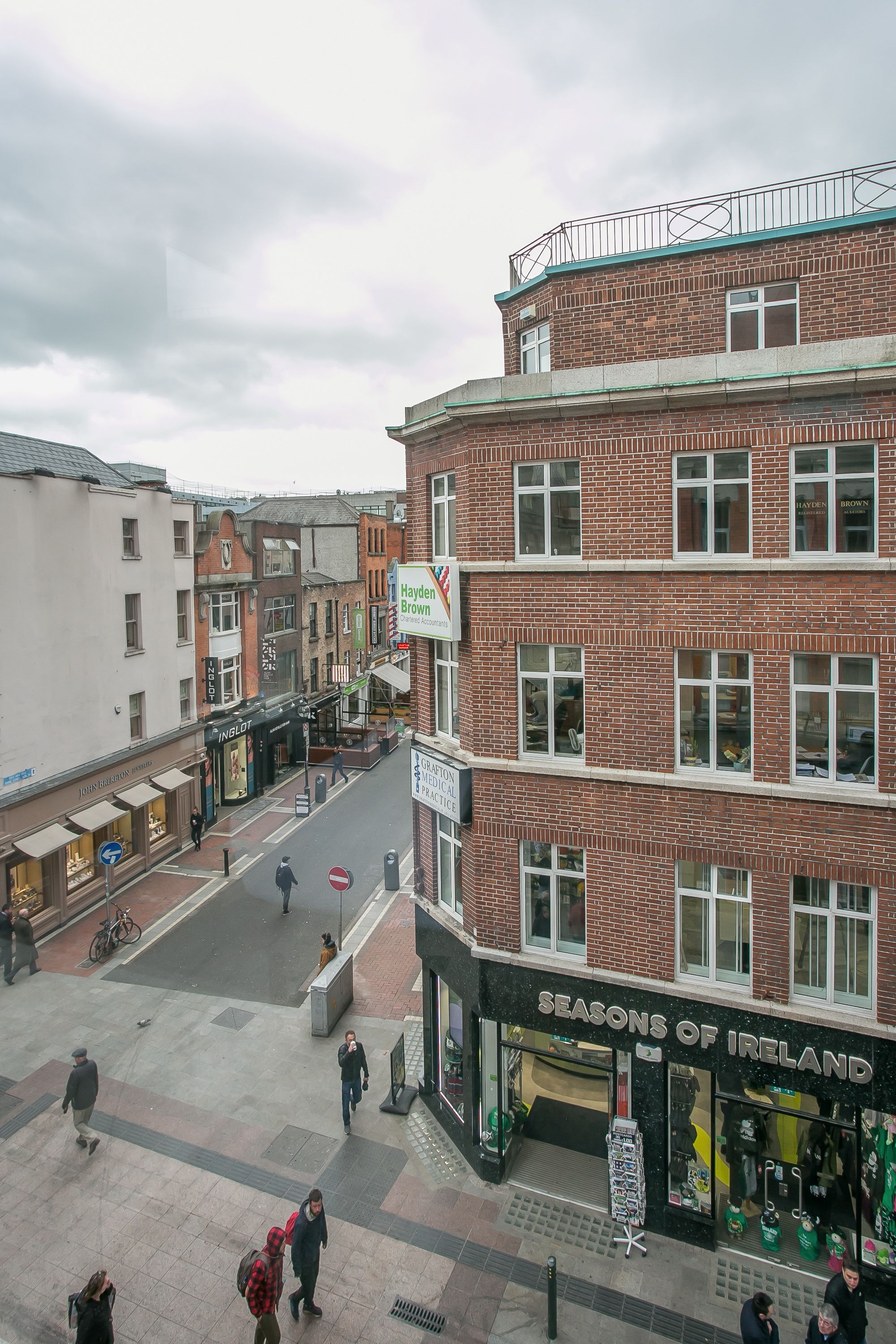 A multi-story building with a brick facade and a sign for 'SEASONS OF IRELAND' on the ground floor.