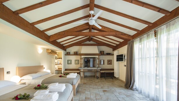 A hotel room with two beds, a ceiling fan, a fireplace, and a television. - B&B Casa Ceruti (Villa Guardia)