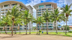 A hotel with multiple floors, balconies, and palm trees. - Diamante del Sol 501N (Jacó)