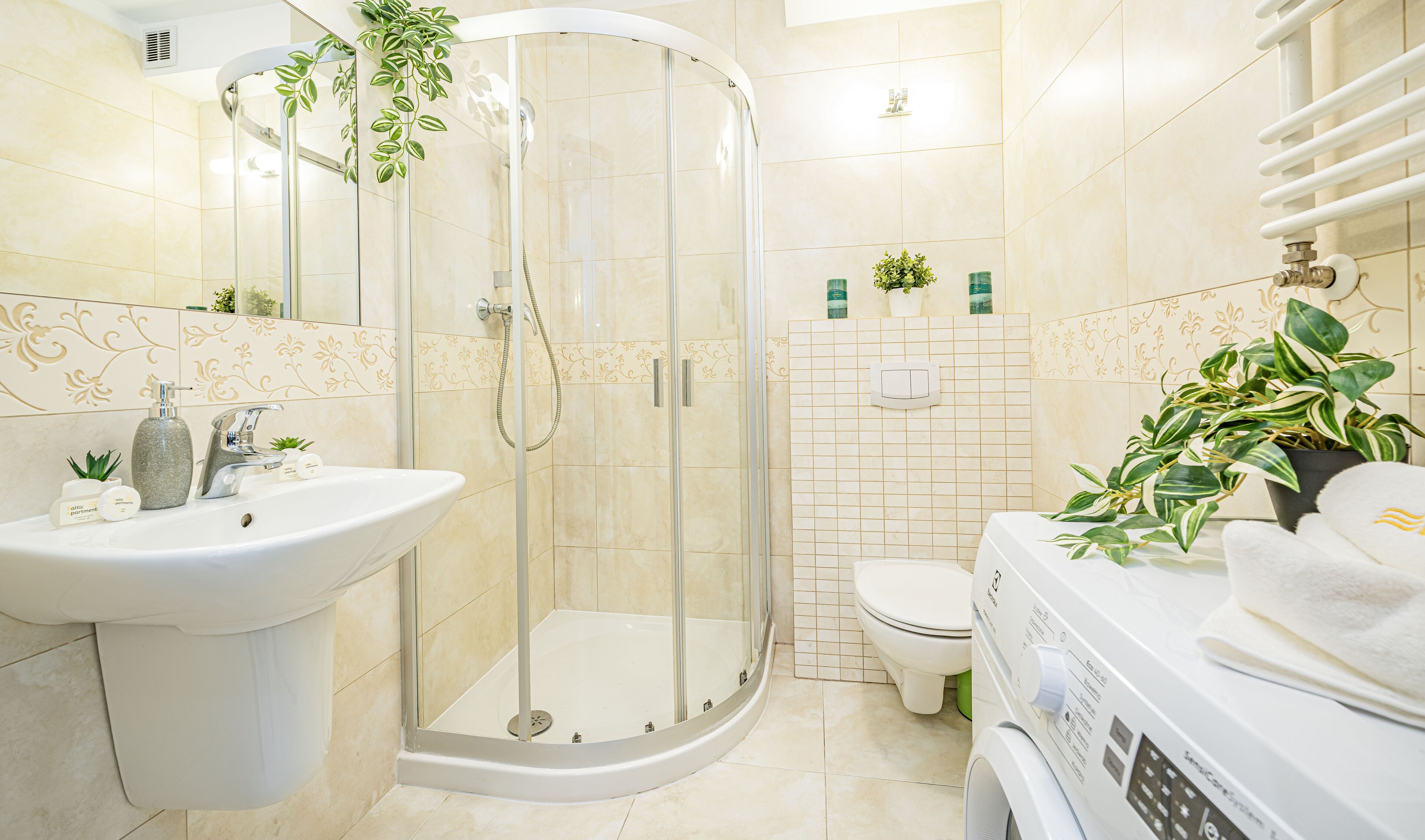 Un baño moderno con ducha envuelta en vidrio, un lavabo blanco y un inodoro.