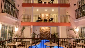 A multi-level indoor pool area with seating and railings.
