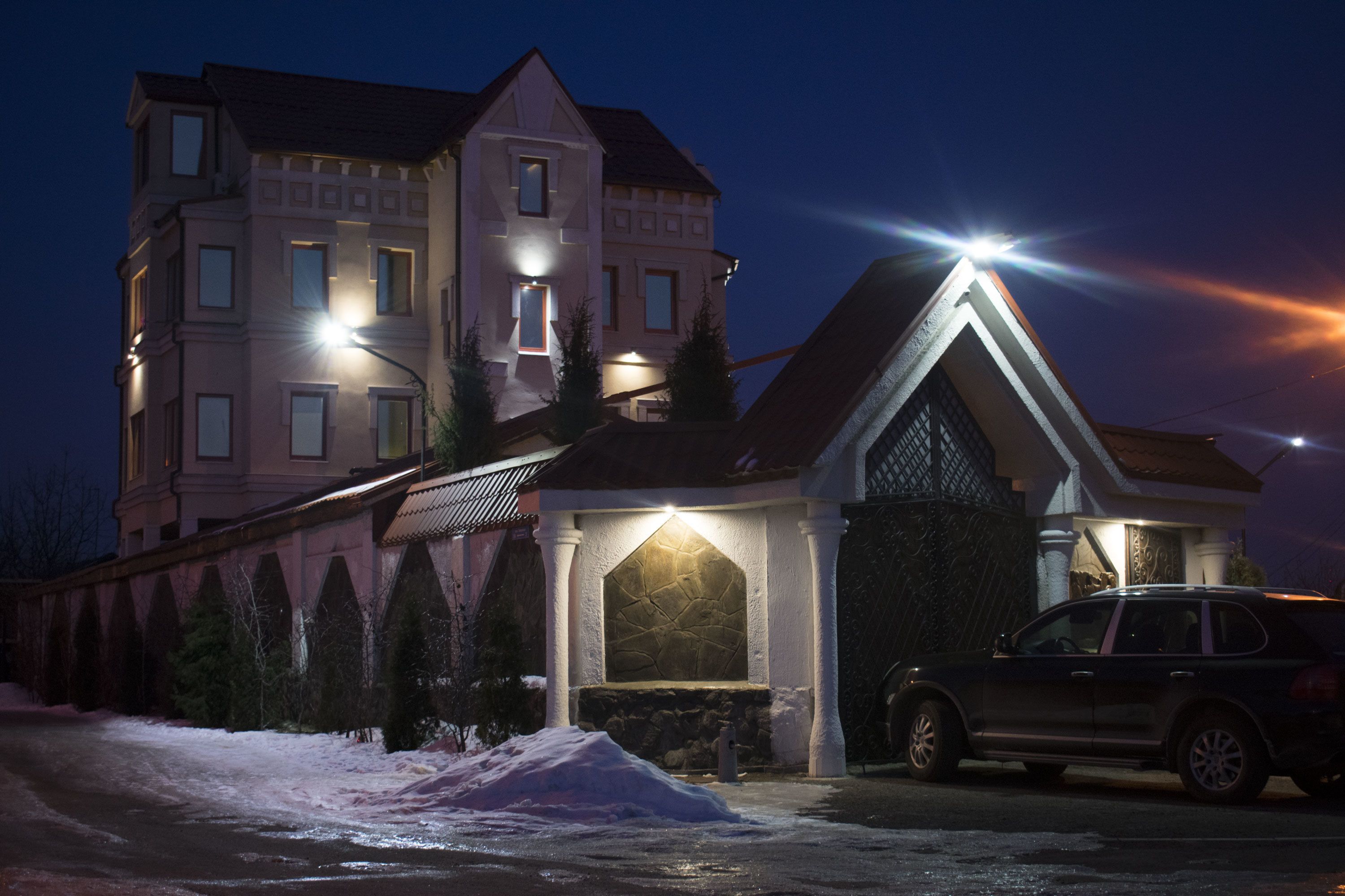 A multi-story building with a stone facade and a lit entrance.