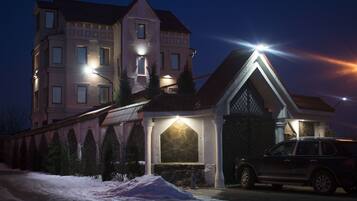 A multi-story building with a stone facade and a lit entrance.
