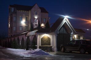 A multi-story building with a stone facade and a lit entrance. - Velion Hotel (Kharkiv)