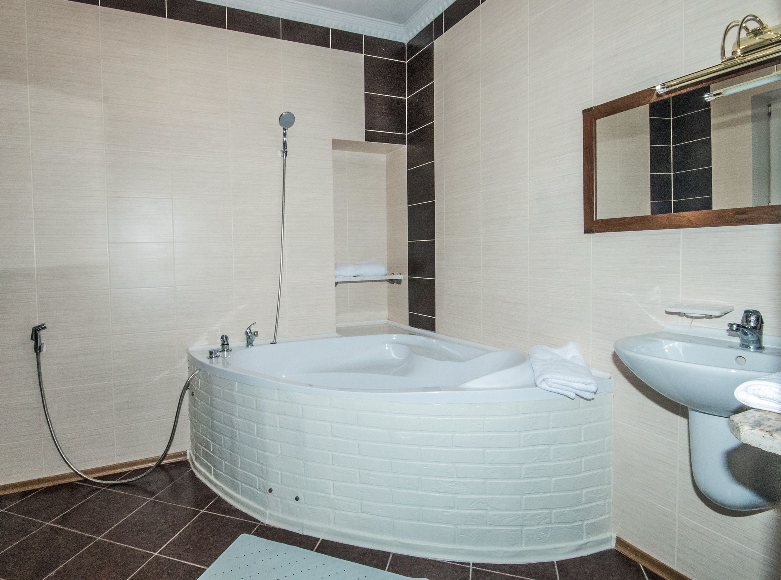 A bathroom with a white bathtub, a sink, and a shower.
