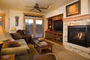 A cozy living room with a fireplace, comfortable seating, and a television.