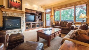 Ein Wohnzimmer mit Kamin, Fernseher und gemütlicher Sitzgelegenheit.