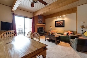Relax in this inviting living room with a sofa, dining table, and fireplace.