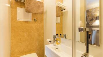 Un baño con un lavabo blanco, un espejo, toallero y un inodoro.